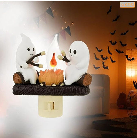 Veilleuse Halloween avec deux fantômes faisant griller des chamallows autour d'un feu de camp, branchée sur une prise